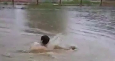 (ВИДЕО) Момче во Белград плива во поплавена улица